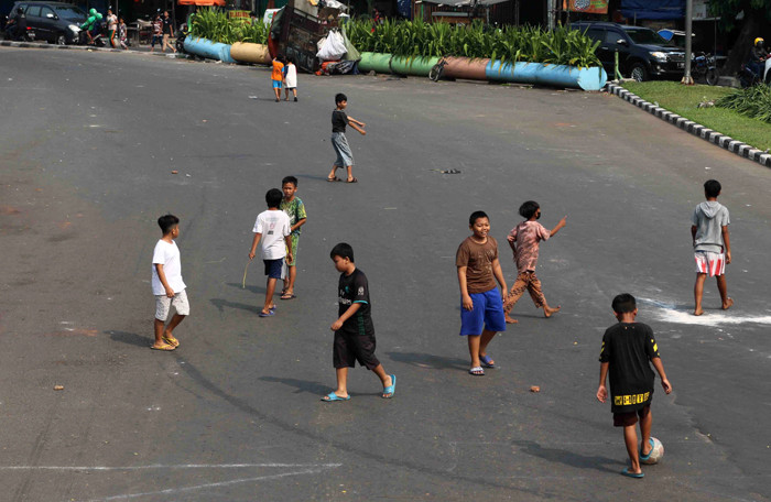 Anak-anak bermain sepak bola di jalan raya yang ditutup dikawasan Kemayoran, Jakarta Pusat, Rabu (7/7/2021).