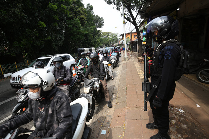 Petugas kepolisian memeriksa dokumen dan persyaratan pengendara di pos penyekatan PPKM Darurat di Jalan Raya Lenteng Agung, Jakarta, Rabu (7/7/2021).