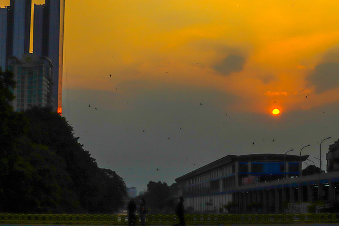 Matahari senja yang akan terbenam menyinari pusat kota di masa Pemberlakuan Pembatasan Kegiatan Masyarakat (PPKM) Darurat di Jakarta Pusat, Rabu (7/7/2021).