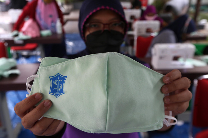 Sejumlah penjahit menyelesaikan pembuatan masker di Balai Kota Surabaya, Jawa Timur, Jumat (9/7/2021).