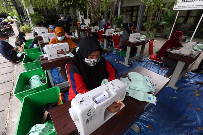 Sejumlah penjahit menyelesaikan pembuatan masker di Balai Kota Surabaya, Jawa Timur, Jumat (9/7/2021).