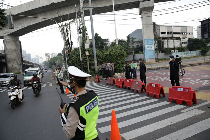 Petugas kepolisian memeriksa pengendara motor di Jalan Fatmawati yang ditutup di Jakarta, Sabtu (10/7/2021).