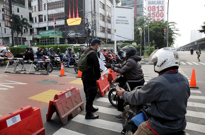 Petugas kepolisian memeriksa pengendara motor di Jalan Fatmawati yang ditutup di Jakarta, Sabtu (10/7/2021).