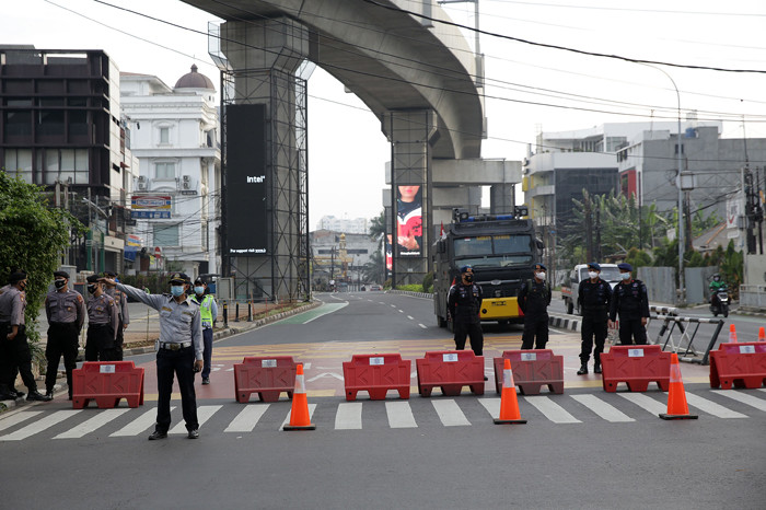 Petugas kepolisian memeriksa pengendara motor di Jalan Fatmawati yang ditutup di Jakarta, Sabtu (10/7/2021).