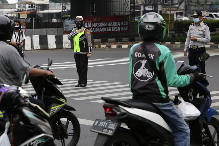Petugas kepolisian bersama pengguna jalan berdoa di Jalan TB Simatupang, Jakarta, Sabtu (10/7/2021).