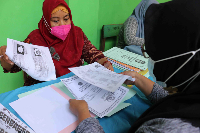 Orang tua calon murid mengembalikan formulir pendaftaran sekolah di SMK Syahid, Cilincing ,Jakarta, Sabtu (10/7/2021).