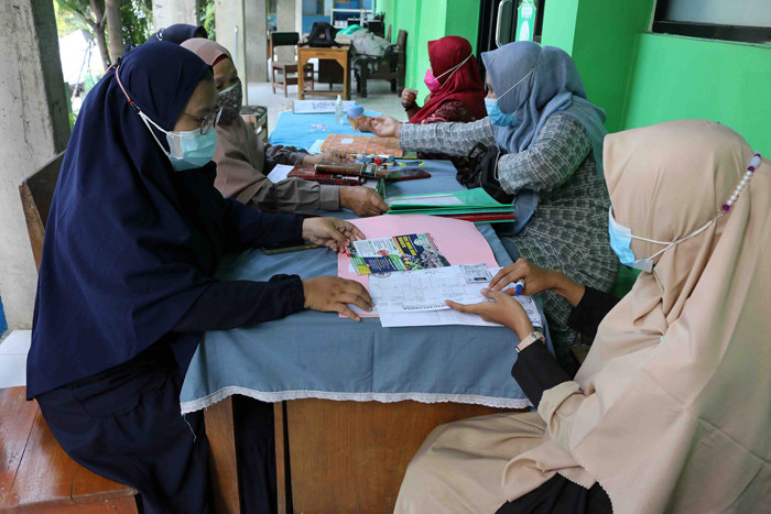 Orang tua calon murid mengembalikan formulir pendaftaran sekolah di SMK Syahid, Cilincing ,Jakarta, Sabtu (10/7/2021).