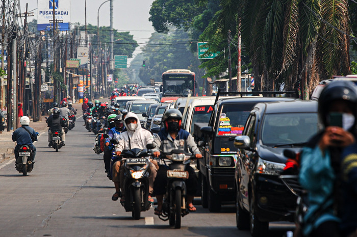Petugas memeriksa KTP warga yang ingin melewati penyekatan di Jalan Molek, Pondok Gede, Kota Bekasi, Jawa Barat, Minggu (11/7/2021).