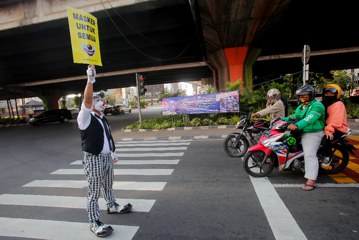 Angggota Komunitas Aku Badut Indonesia (ABI) melakukan aksi kampanye untuk menggunakan masker di Kawasan Fatmawati, Jakarta Selatan, Senin (12/7/2021).