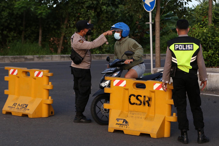 Petugas mengarahkan pengendara untuk putar balik saat akan masuk kota Surabaya melalui akses masuk dari Surabaya Timur di Jawa Timur, Senin (12/7/2021).