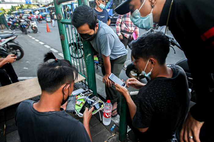 Tukang service Handphone menawarkan jasanya dipinggir jalan di kawasan Cililitan, Jakarta Timur, Senin (12/7/2021).
