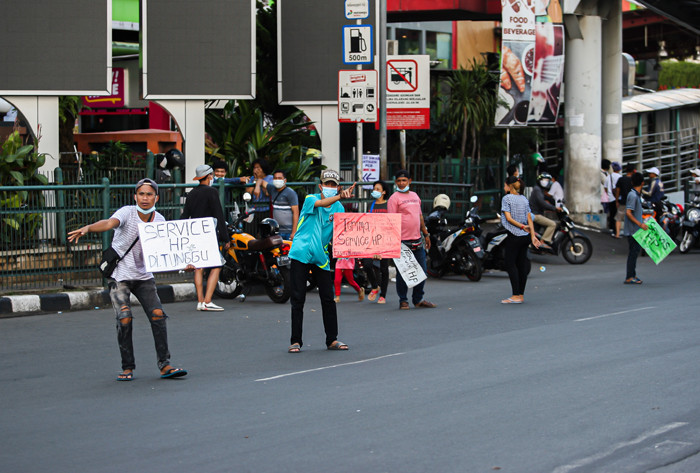 Tukang service Handphone menawarkan jasanya dipinggir jalan di kawasan Cililitan, Jakarta Timur, Senin (12/7/2021).