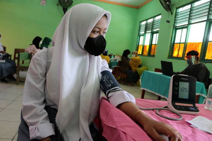 Ratusan pelajar SMP dan SMK Syahid saat mengikuti program vaksin Covid- 19 di Cilincing Jakarta Utara, Selasa (13/7/2021).