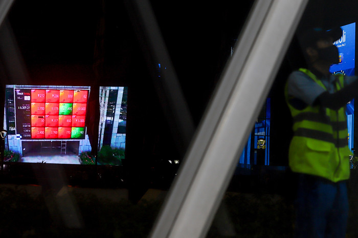 Pengendara saat melintas dengan berlatar belakang tampilan iklan videotron di gedung Bursa Efek Indonesia, Jakarta, Rabu (14/7/2021).