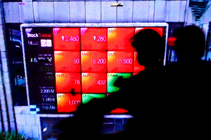 Pengendara saat melintas dengan berlatar belakang tampilan iklan videotron di gedung Bursa Efek Indonesia, Jakarta, Rabu (14/7/2021).