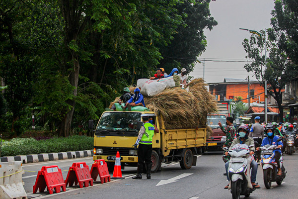 Petugas berjaga di pos penyekatan Pemberlakuan Pembatasan Kegiatan Masyarakat (PPKM) Darurat Lenteng Agung, Jakarta Selatan, Rabu (14/7/2021).