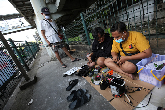 Sejumlah tukang servis handphone menawarkan jasanya di sekitar Pusat Grosir Cililitan (PGC), Jakarta Timur, Rabu (14/7/2021).