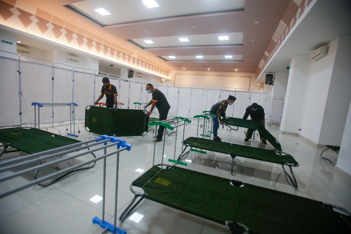 Petugas menyiapkan velbed untuk warga yang akan menjalani isolasi mandiri di Gelanggang Olahraga (GOR) Kecamatan Matraman, Jakarta Timur, Rabu (14/7/2021).