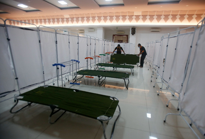 Petugas menyiapkan velbed untuk warga yang akan menjalani isolasi mandiri di Gelanggang Olahraga (GOR) Kecamatan Matraman, Jakarta Timur, Rabu (14/7/2021).