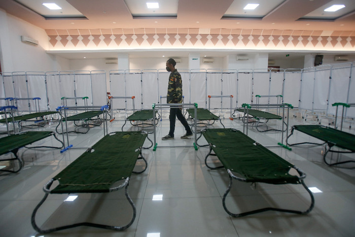 Petugas menyiapkan velbed untuk warga yang akan menjalani isolasi mandiri di Gelanggang Olahraga (GOR) Kecamatan Matraman, Jakarta Timur, Rabu (14/7/2021).
