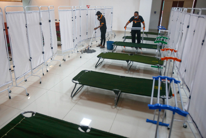 Petugas menyiapkan velbed untuk warga yang akan menjalani isolasi mandiri di Gelanggang Olahraga (GOR) Kecamatan Matraman, Jakarta Timur, Rabu (14/7/2021).