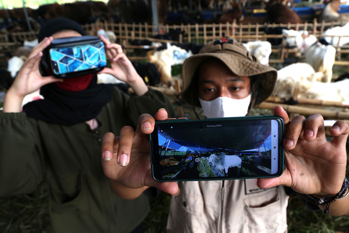 Calon pembeli mencoba pengalaman belanja hewan Kurban menggunakan teknologi Virtual Reality di kandang Ternaknesia Merr Surabaya, Jawa Timur, Kamis (15/7/2021).