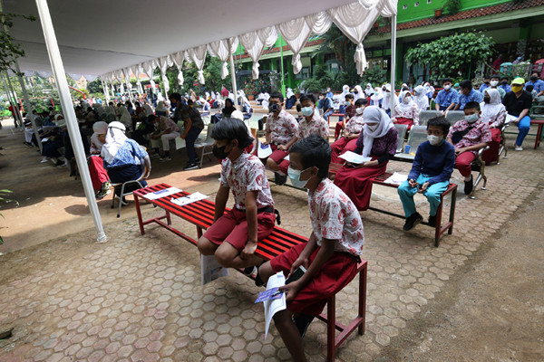 Sejumlah pelajar antre untuk melakukan vaksinasi Covid-19 di SMA 38 Jakarta, Kamis (15/7/2021).
