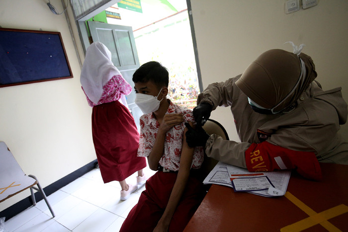 Sejumlah pelajar antre untuk melakukan vaksinasi Covid-19 di SMA 38 Jakarta, Kamis (15/7/2021).