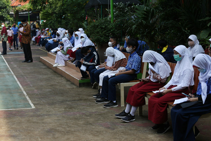 Sejumlah pelajar antre untuk melakukan vaksinasi Covid-19 di SMA 38 Jakarta, Kamis (15/7/2021).