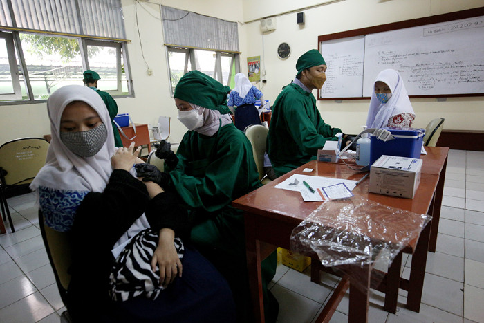 Sejumlah pelajar antre untuk melakukan vaksinasi Covid-19 di SMA 38 Jakarta, Kamis (15/7/2021).