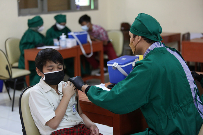 Sejumlah pelajar antre untuk melakukan vaksinasi Covid-19 di SMA 38 Jakarta, Kamis (15/7/2021).