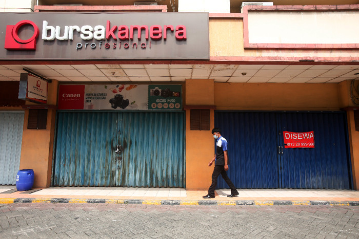 Pekerja berjalan di kawasan pertokoan yang tutup di ITC Fatmawati, Jakarta Selatan, Jumat (16/7/2021).