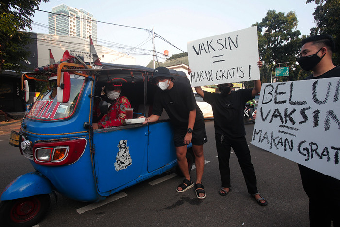Barista membagikan makanan siap saji di depan Kopi Muja, Kebayoran Baru, Jakarta Selatan, Jumat (16/7/2021).