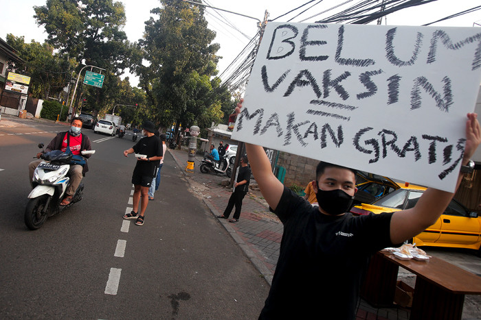 Barista membagikan makanan siap saji di depan Kopi Muja, Kebayoran Baru, Jakarta Selatan, Jumat (16/7/2021).