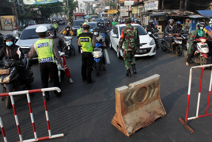 Petugas gabungan mengatur arus lalu lintas saat penyekatan masa PPKM Darurat di kawasan Sandartex Ciputat Tangerang Selatan, Jakarta, Jumat (16/7/2021).