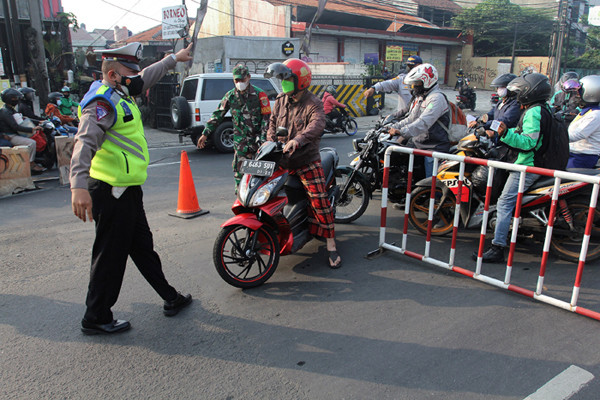 Petugas gabungan mengatur arus lalu lintas saat penyekatan masa PPKM Darurat di kawasan Sandartex Ciputat Tangerang Selatan, Jakarta, Jumat (16/7/2021).