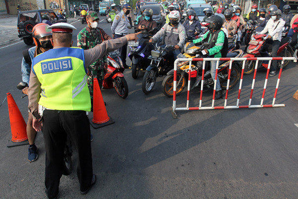 Petugas gabungan mengatur arus lalu lintas saat penyekatan masa PPKM Darurat di kawasan Sandartex Ciputat Tangerang Selatan, Jakarta, Jumat (16/7/2021).