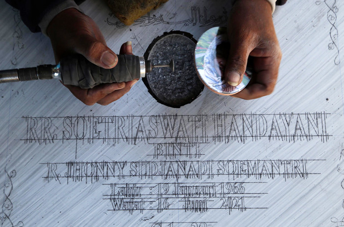 Perajin menyelesaikan pembuatan batu nisan disalah satu rumah produksi Keputih Surabaya, Jawa Timur, Jumat (16/7/2021).