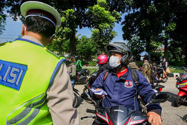 Petugas saat memeriksa kelengkapan warga yang ingin melintas di pos penyekatan PPKM Darurat Lenteng Agung, Jakarta Selatan, Jumat (16/7/2021).