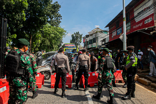 Petugas saat memeriksa kelengkapan warga yang ingin melintas di pos penyekatan PPKM Darurat Lenteng Agung, Jakarta Selatan, Jumat (16/7/2021).