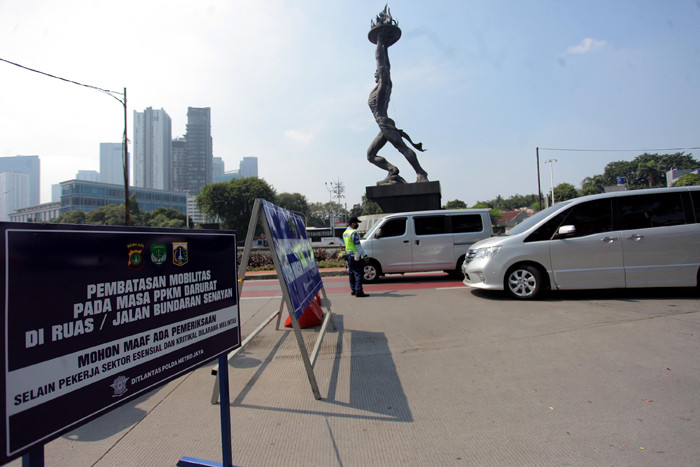Petugas kepolisian memeriksa kendaraan di pos penyekatan PPKM Darurat di kawasan Jalan Jenderal Sudirman, Jakarta, Sabtu (17/7/2021).