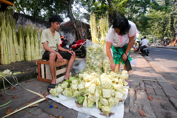 Penjual menyelesaikan pembuatan kulit ketupat di Pasar Palmerah, Jakarta Pusat, Minggu (18/7/2021).