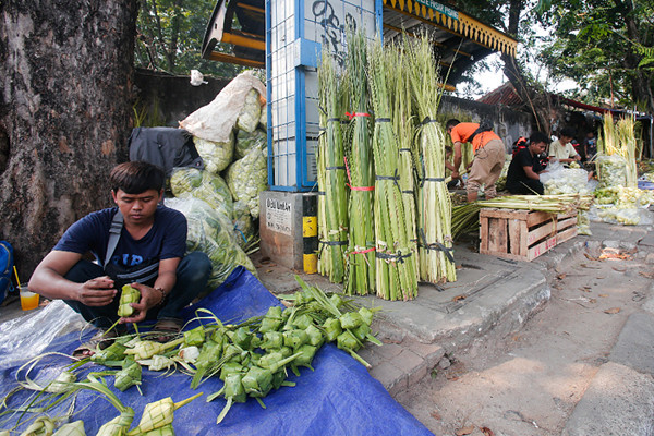 Penjual menyelesaikan pembuatan kulit ketupat di Pasar Palmerah, Jakarta Pusat, Minggu (18/7/2021).