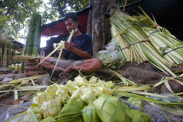Penjual menyelesaikan pembuatan kulit ketupat di Pasar Palmerah, Jakarta Pusat, Minggu (18/7/2021).