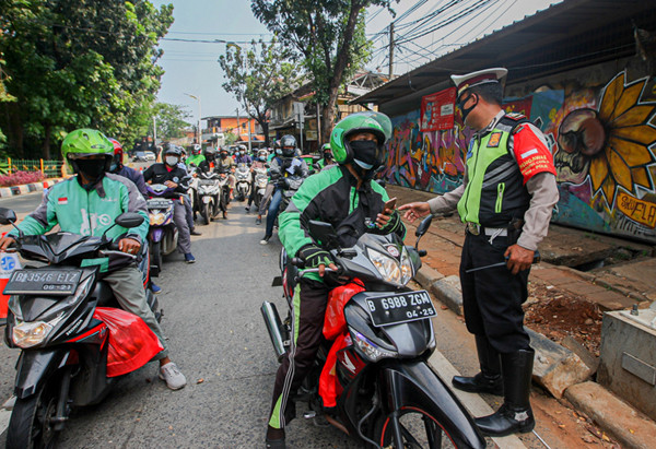 Pengemudi Ojek Online saat melintas di pos penyekatan PPKM Darurat Lenteng Agung, Jakarta Selatan, Minggu (18/7/2021).