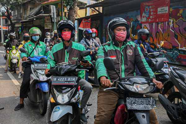 Pengemudi Ojek Online saat melintas di pos penyekatan PPKM Darurat Lenteng Agung, Jakarta Selatan, Minggu (18/7/2021).
