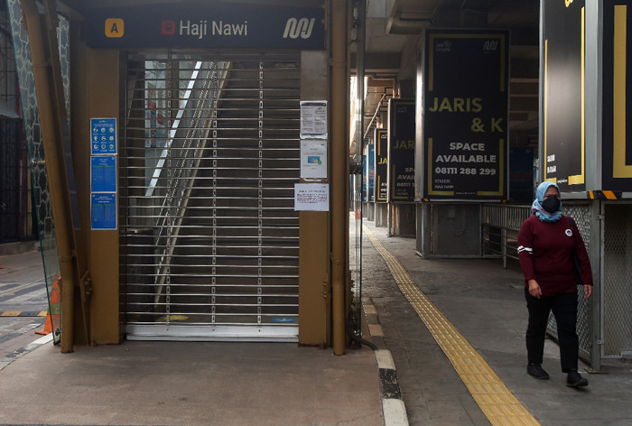 Kertas pengumuman penutupan sementara terpasang di pintu Stasiun MRT Haji Nawi, Jakarta Selatan, Minggu (18/7/2021).