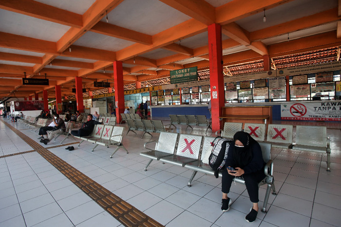 Calon penumpang menunggu kedatangan bus di Terminal Kampung Rambutan, Jakarta Timur, Minggu (18/7/2021).