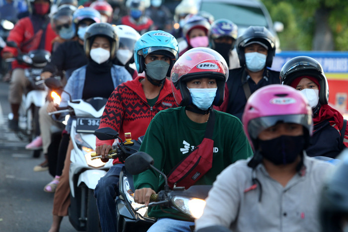 Petugas melakukan pengecekan dokumen pengendara yang melintas di pos penyekatan Jembatan Suramadu, sisi Surabaya, Jawa Timur, Senin (19/7/2021).
