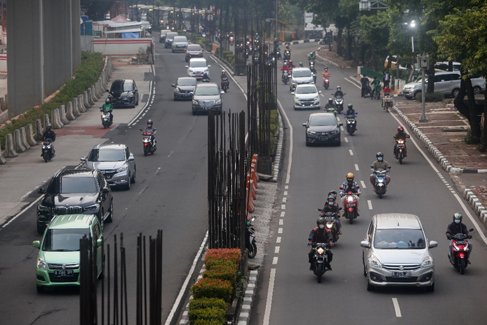 Pengendara melintas di dekat tiang-tiang bekas proyek monorel di Jalan Rasuna Said, Kuningan, Jakarta, Senin (19/7/2021).